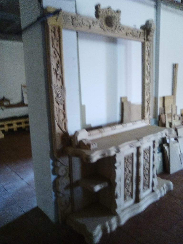 Marco y paneles de madera tallada apoyados en el taller